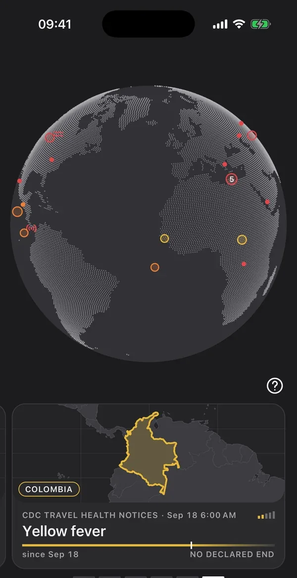 The Now screen in dark mode: the globe with the events in force and the card for a yellow fever health notice in Colombia